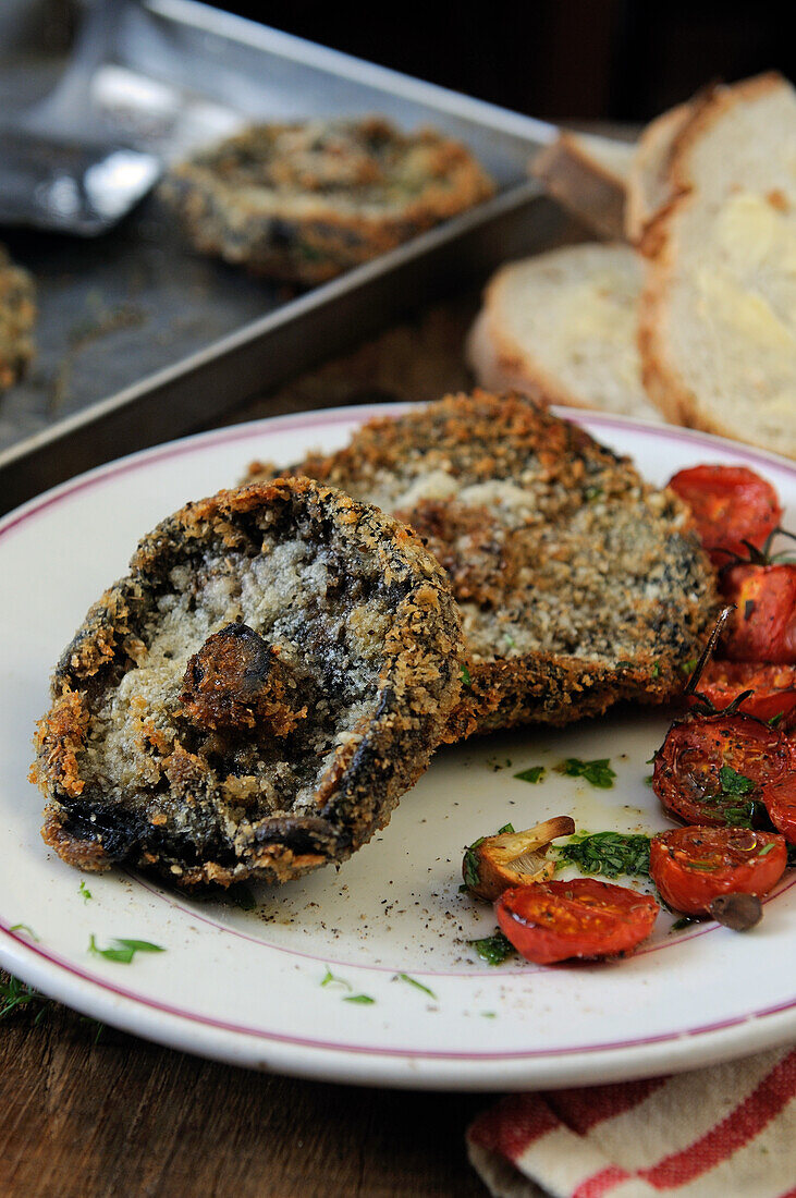 Breaded fried portobello mushrooms with roasted tomatoes