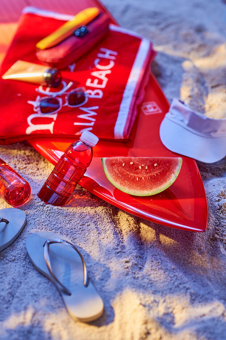 Surfbrett mit Wassermelone am Strand