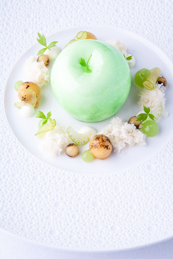 Apple filled with sugar foam and pickled apple balls in vanilla broth