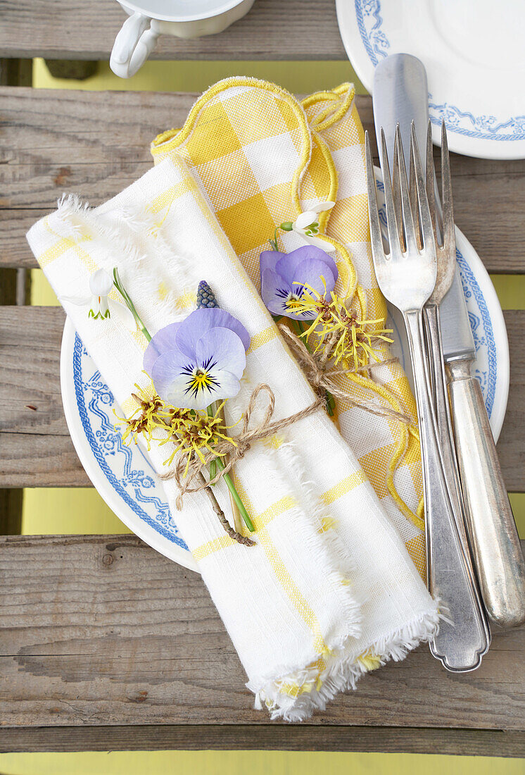 Summery table with yellow and white chequered napkins and flower decorations