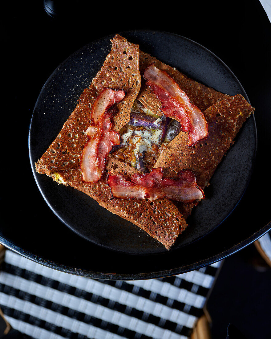 Galette mit Raclettekäse, roten Zwiebeln und knusprigem Speck