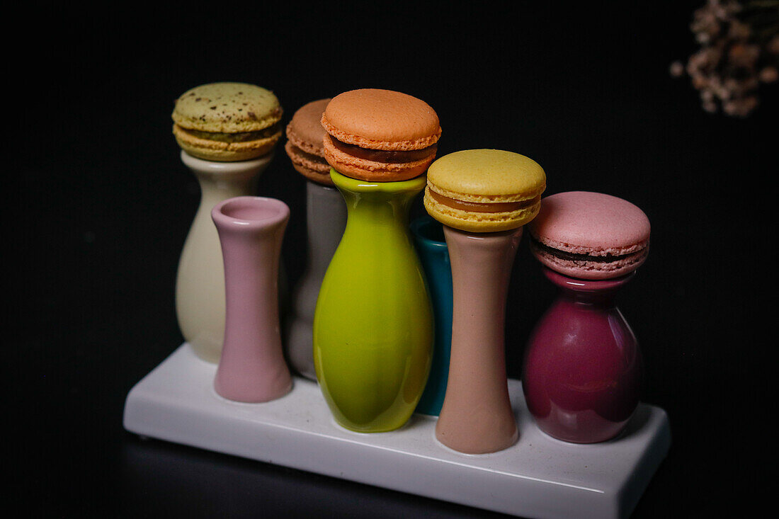 Macarons on colourful ceramic vases