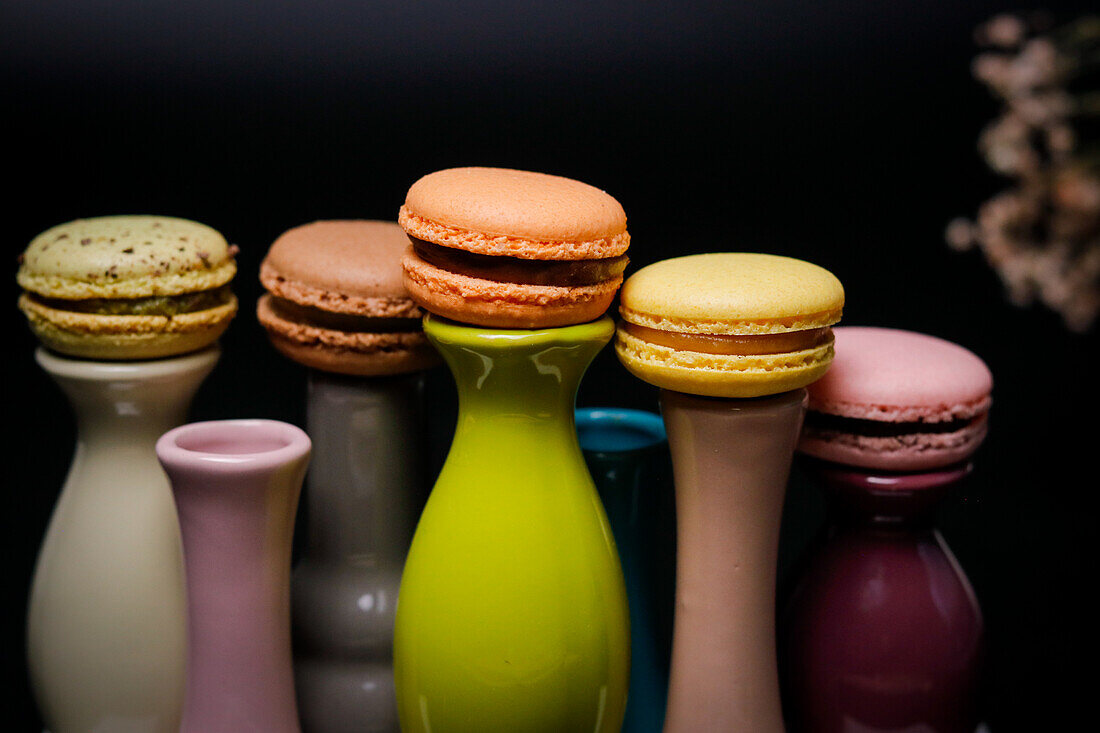 Macarons auf bunten Keramikvasen