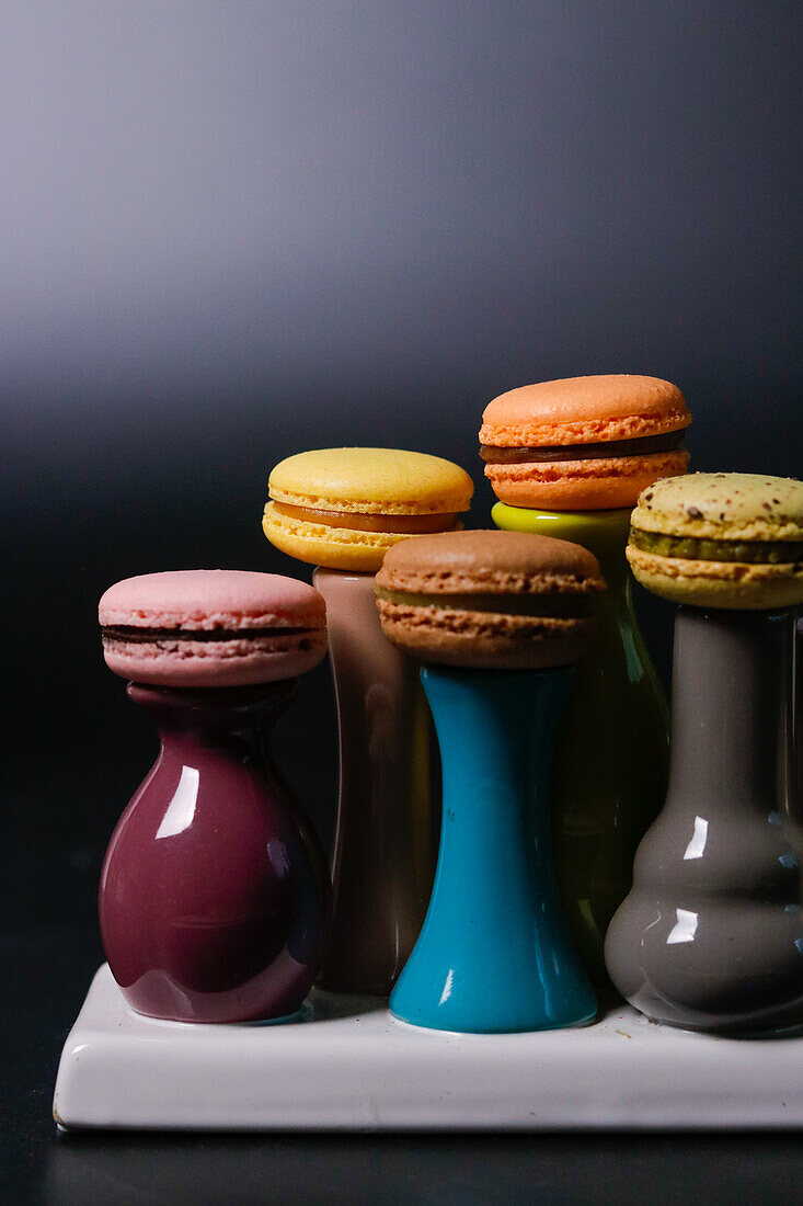 Macarons auf bunten Keramikvasen