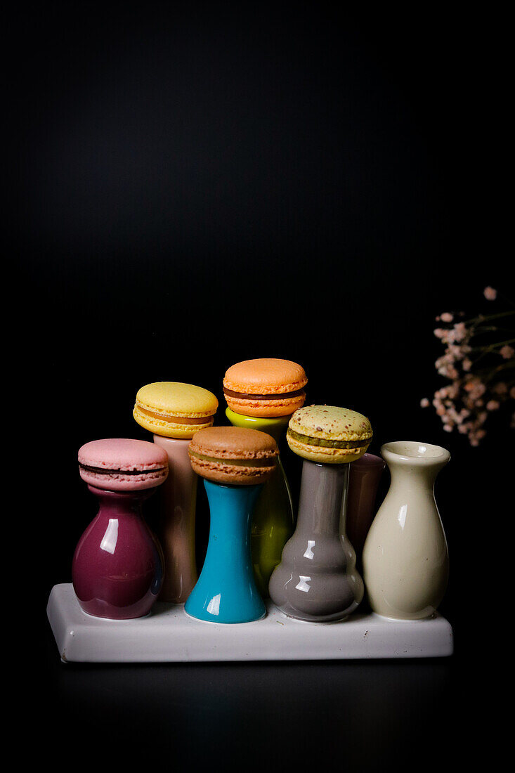 Macarons on colourful ceramic vases