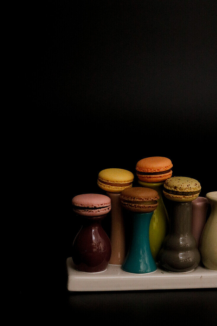 Macarons on colourful ceramic vases