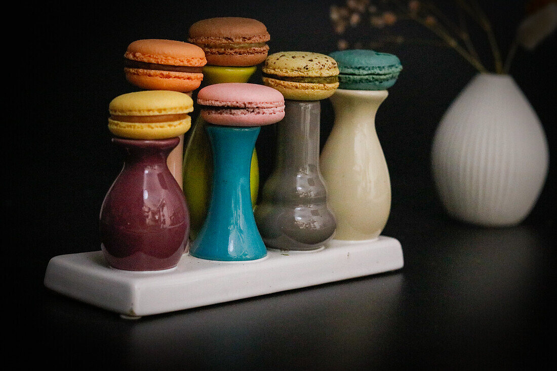 Macarons on colourful ceramic vases