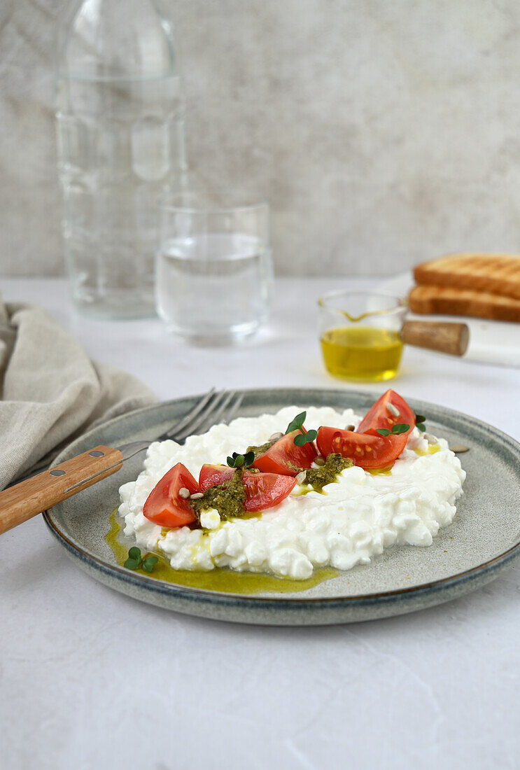 Körniger Frischkäse mit Kirschtomaten und Pesto