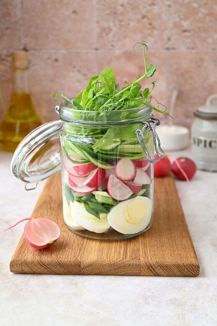 Salad with radish, egg, onions and cucumber in a jar