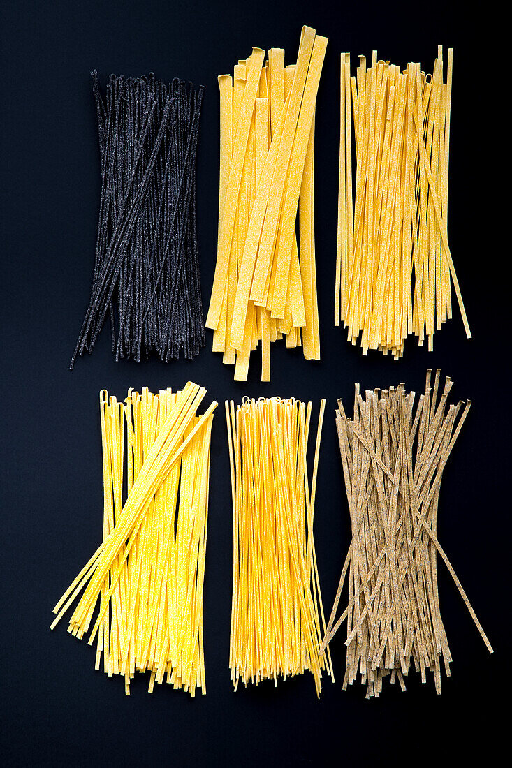 Various types of pasta on a black background