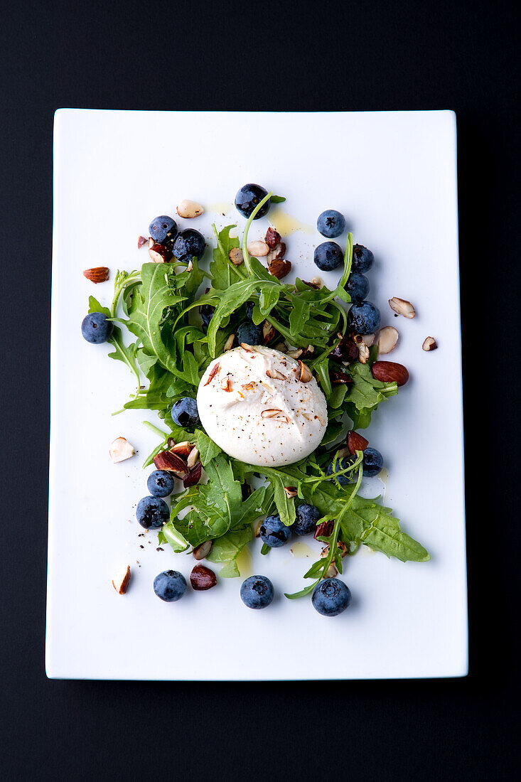 Burrata on rocket salad with blueberries and hazelnuts