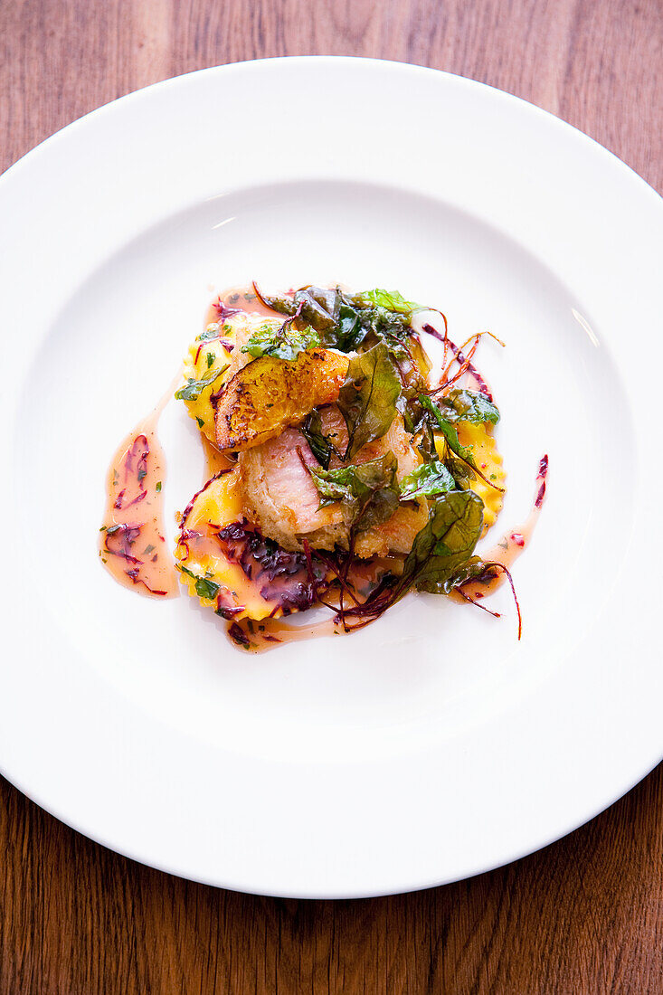 Veal with ravioli, fried basil and red chicory strips