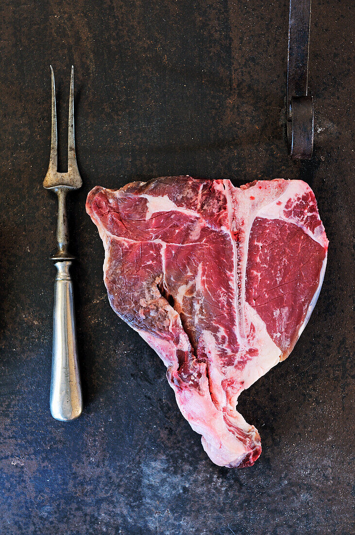 Rohes T-Bone-Steak und Fleischgabel