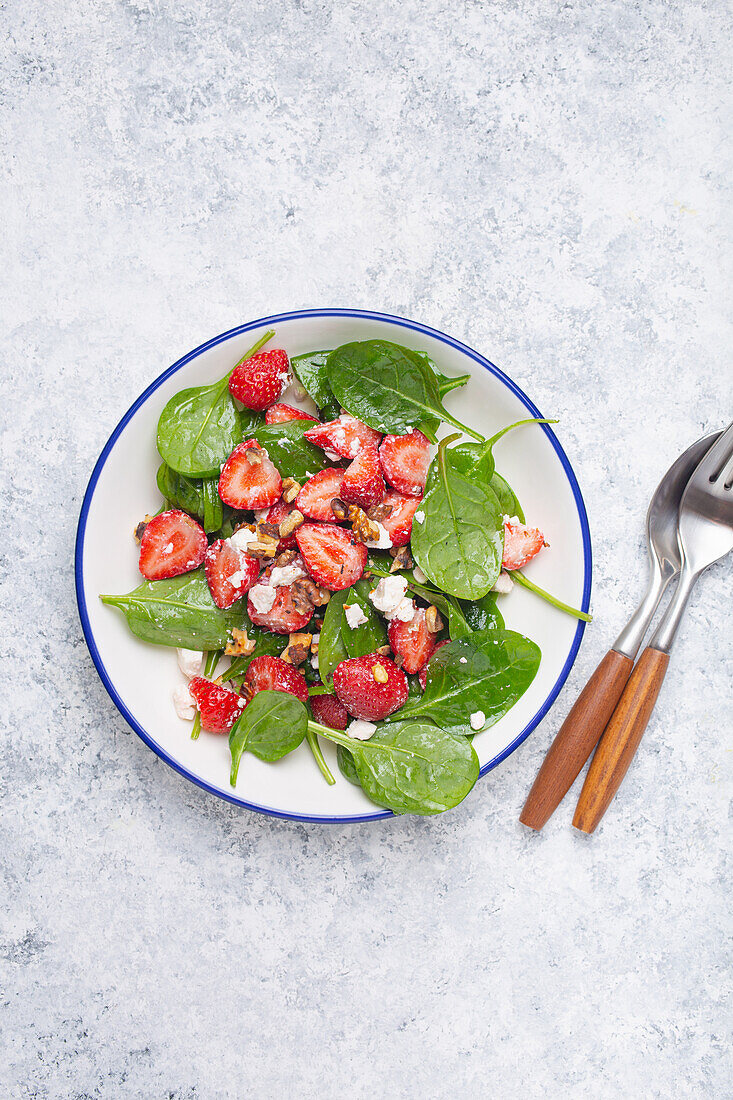Summer salad with fresh strawberries, spinach, cream cheese, and walnuts