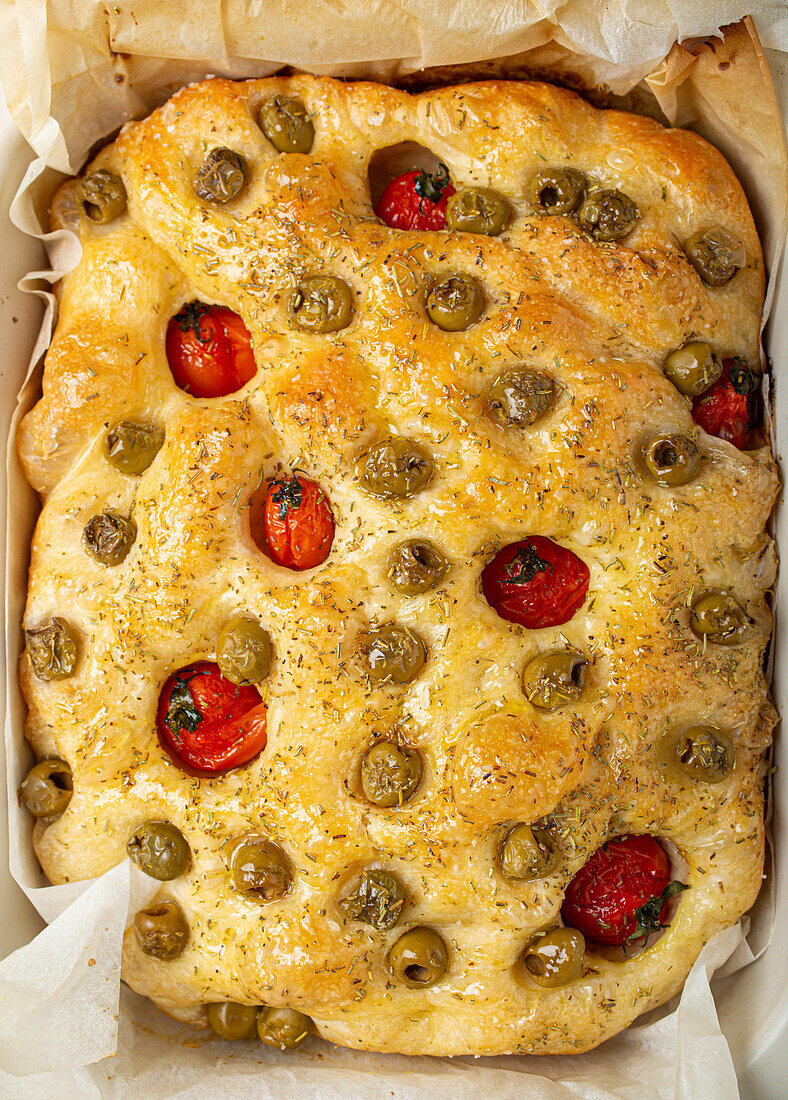 Focaccia with green olives, olive oil, cherry tomatoes, and rosemary
