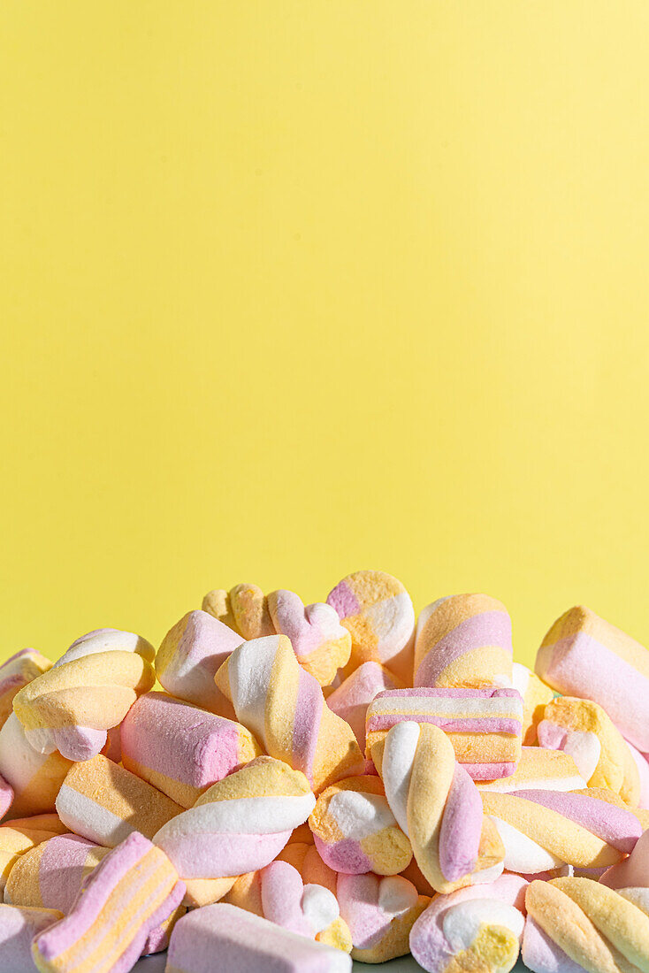 Colorful marshmallows on a yellow background