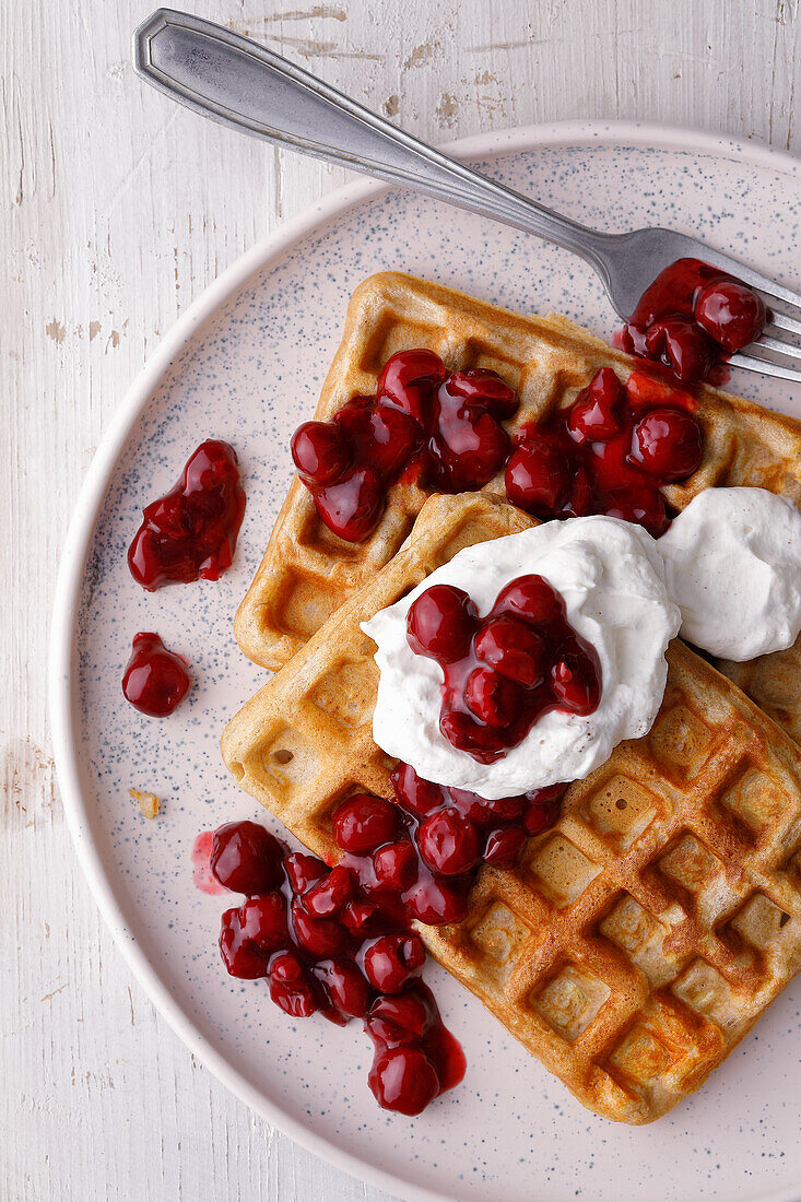 Waffles with hot cherries and cream