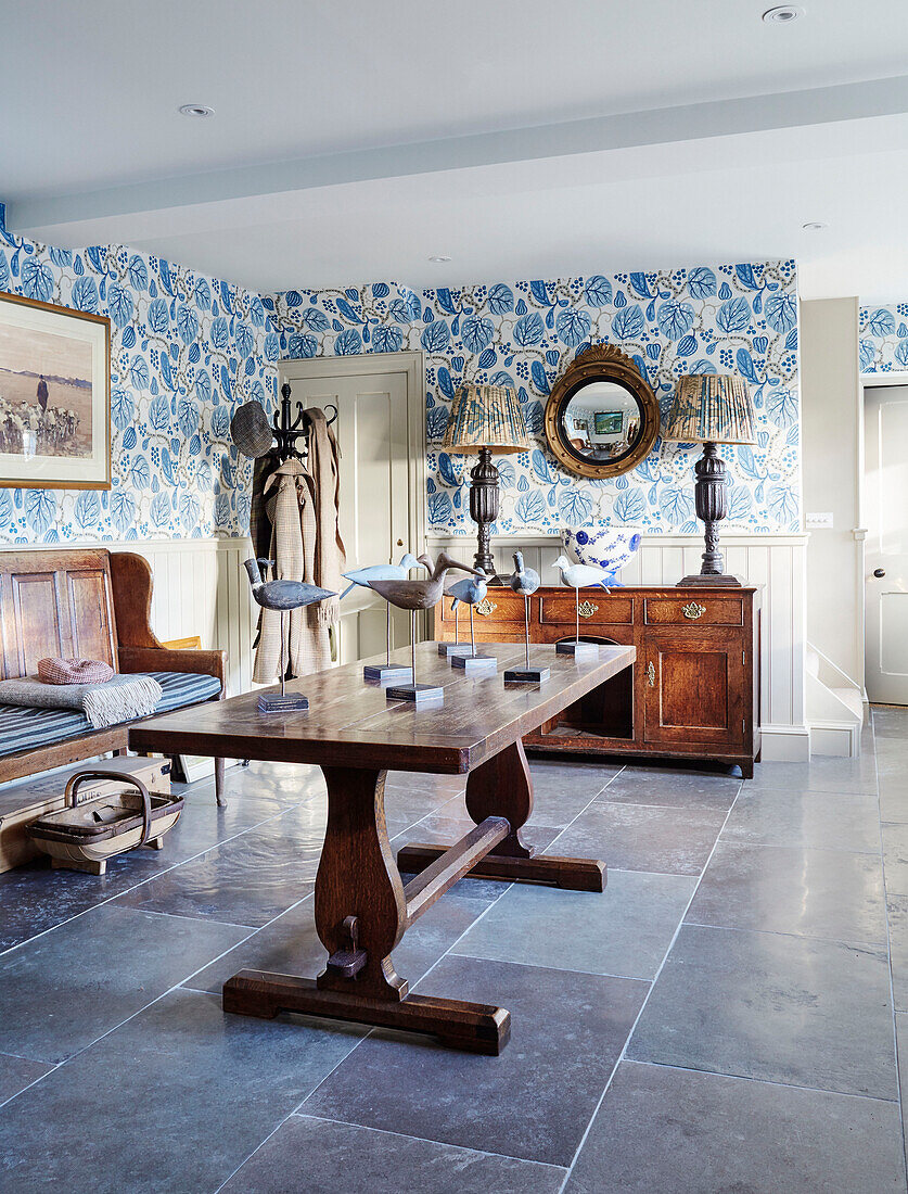 Bird ornaments on old wooden table with sideboard and lamps in North Yorkshire farmhouse, UK