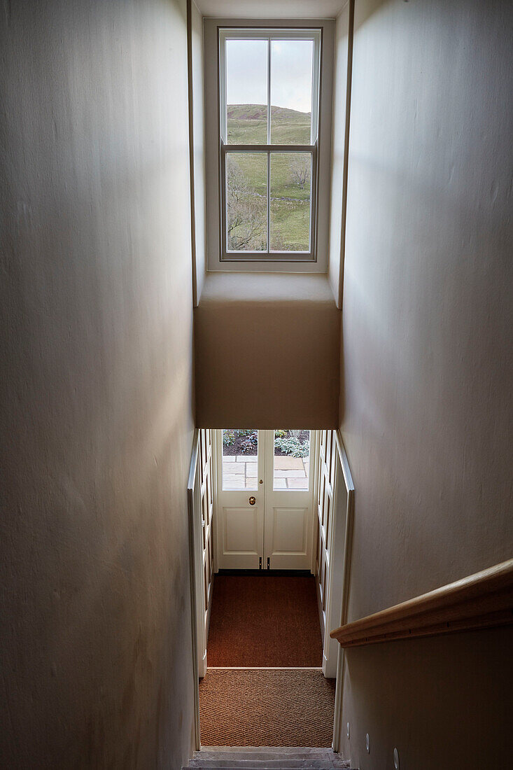 Doppelhohe Treppe und Fenster mit Aussicht in einem Bauernhaus in North Yorkshire, UK