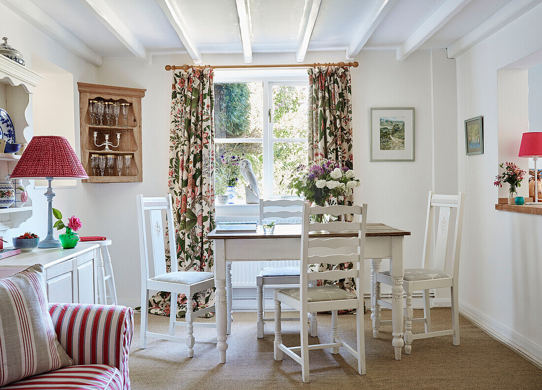 Geblümte Vorhänge und Eckschrank mit Esstisch und Stühlen in einem britischen Landhaus