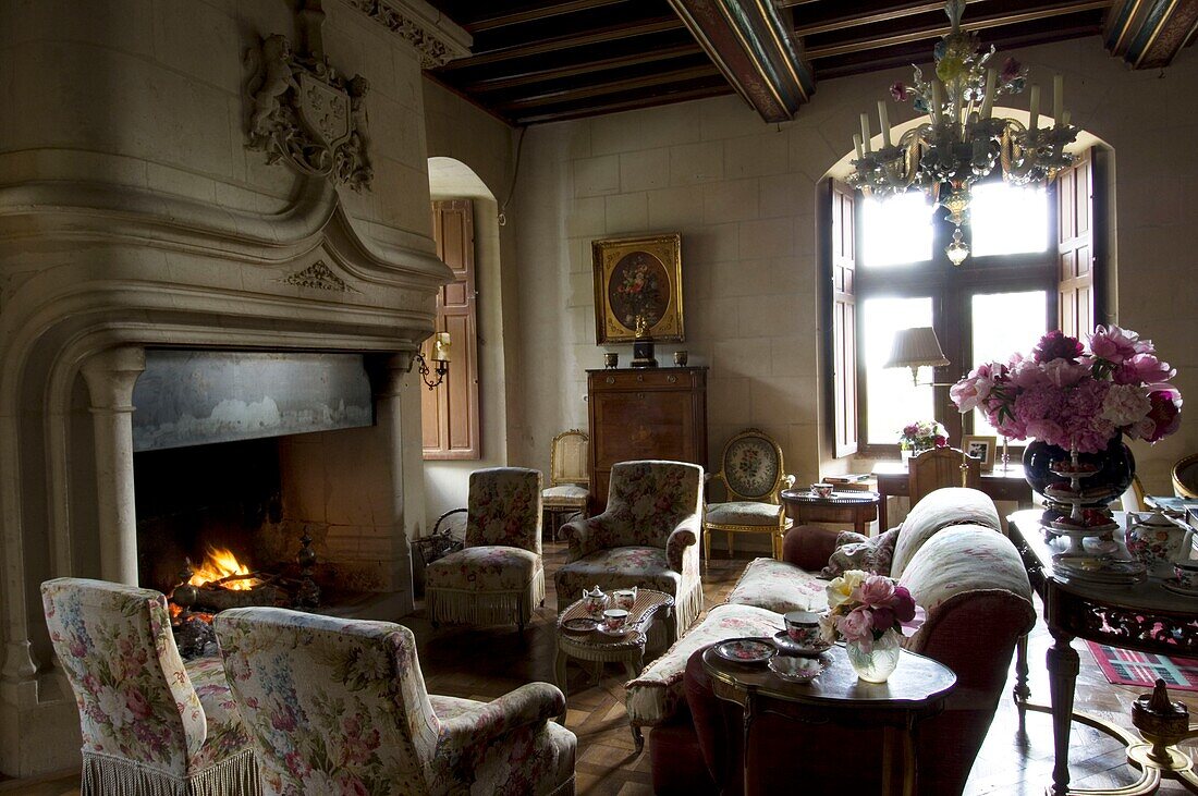 Armchairs surrounding fireplace in opulent living room