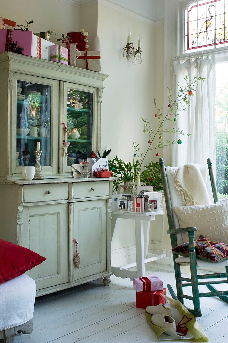 Living room with rocking chair, christmas decoration and Christmas presents on cupboard