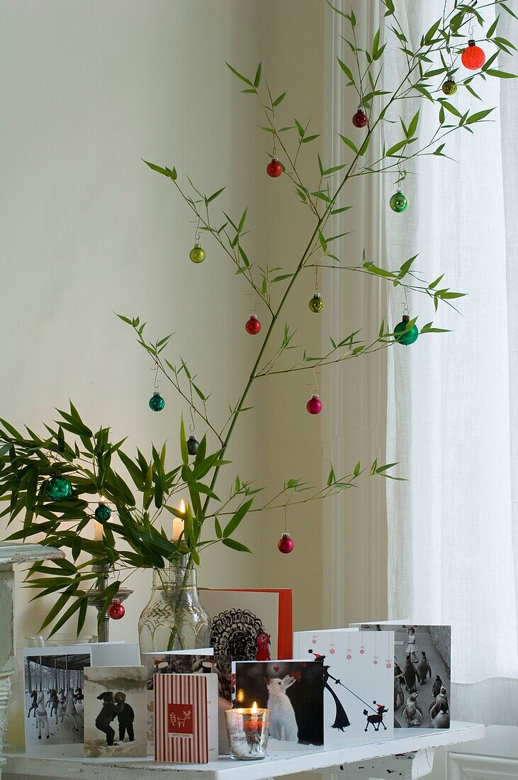 Christmas decoration, greeting cards and burning candles on coffee table