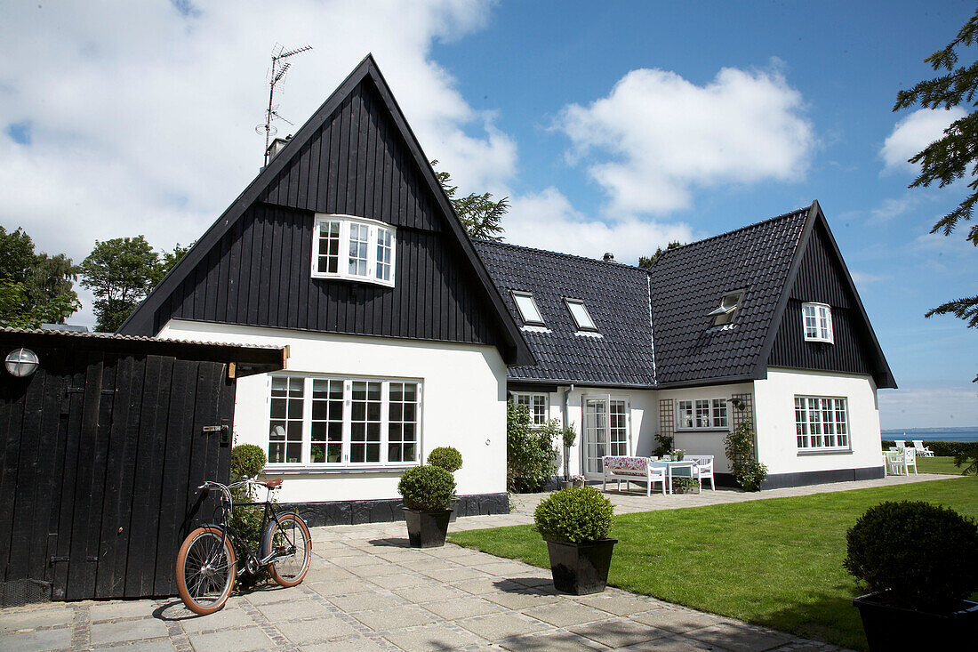 Außenansicht eines Hauses und eines sonnigen Gartens