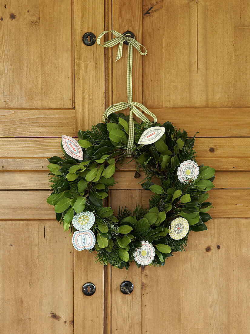 Weihnachtsblumenkranz an einem hölzernen Kleiderschrank in einem Cottage in Herefordshire, UK