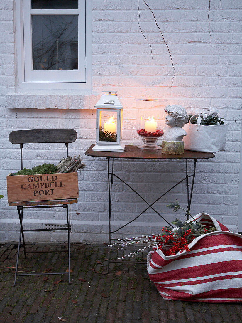 Cut flowers and lit lantern on patio table in Herefordshire garden exterior England, UK