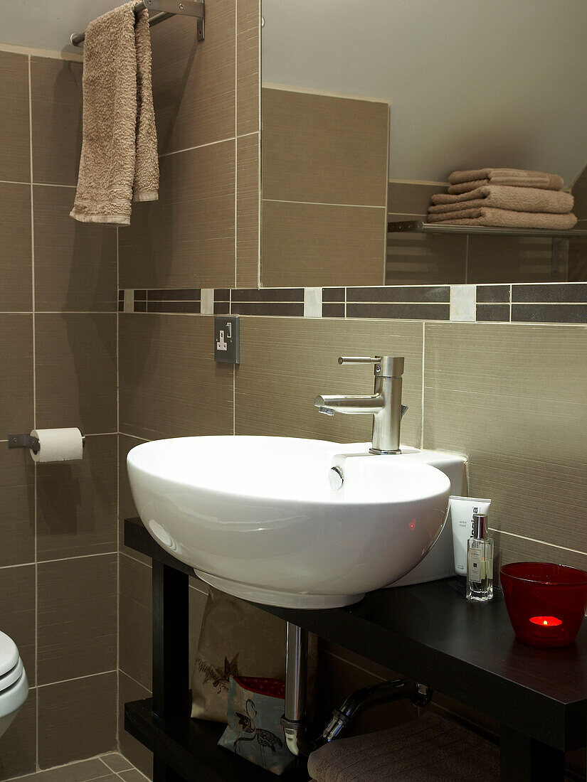 Washbasin under mirror in tiled bathroom, Poland