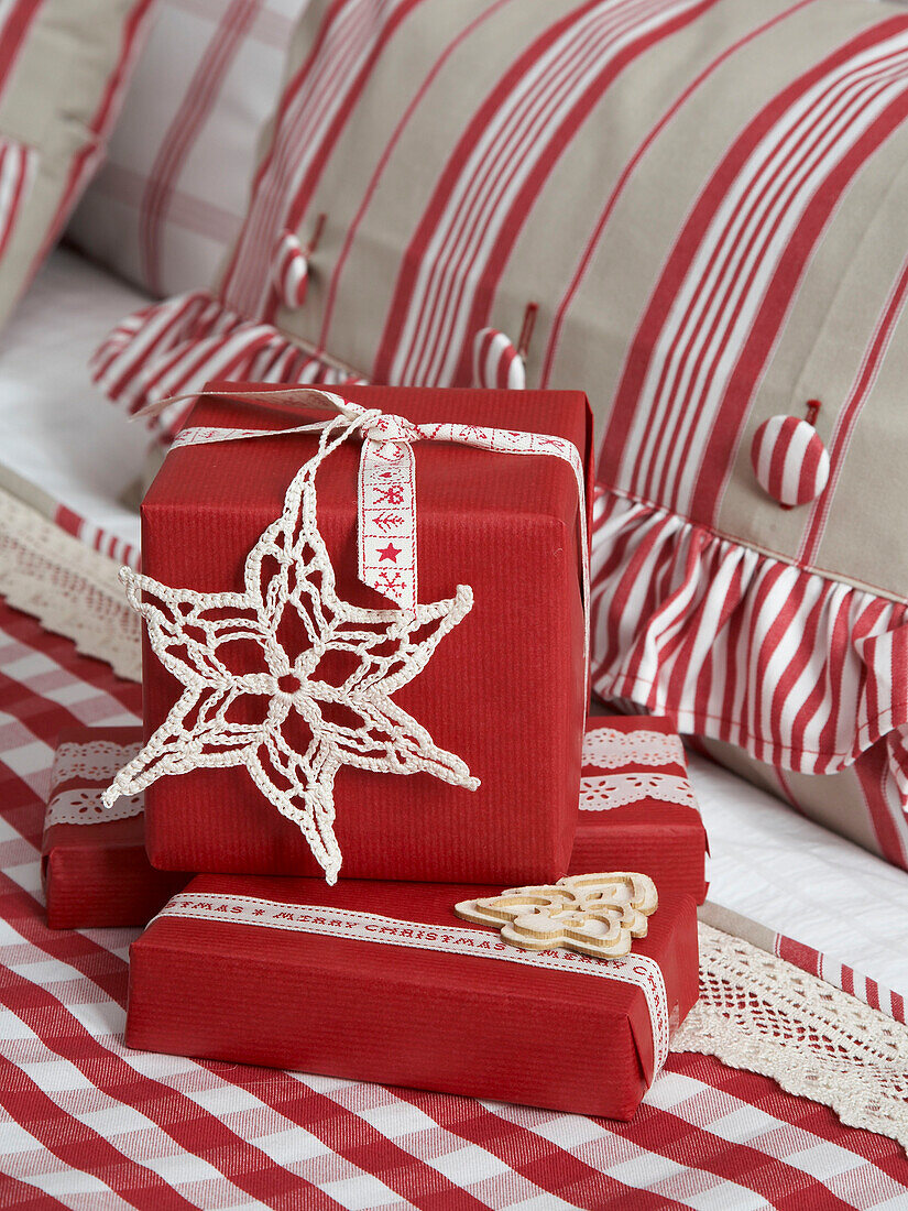 Handmade snowflakes on red gift wrapped Christmas presents in Polish home