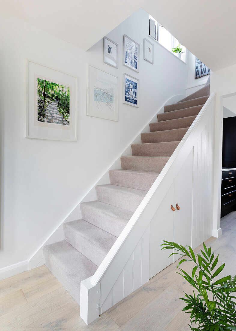 Artwork in open plan carpeted staircase in Reigate home, Surrey, UK