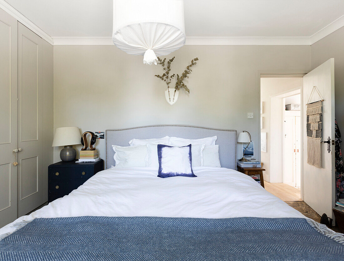 Eucalyptus above bed with upcycled bedside units and light made from wooden hoops and muslin in Colchester home Essex UK