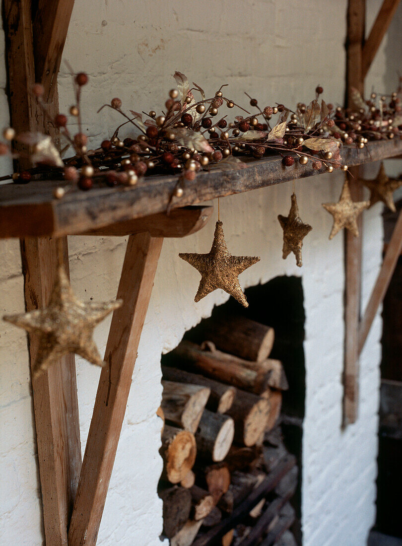 Christmas decorations displayed on a wooden mantelpiece above an open fire