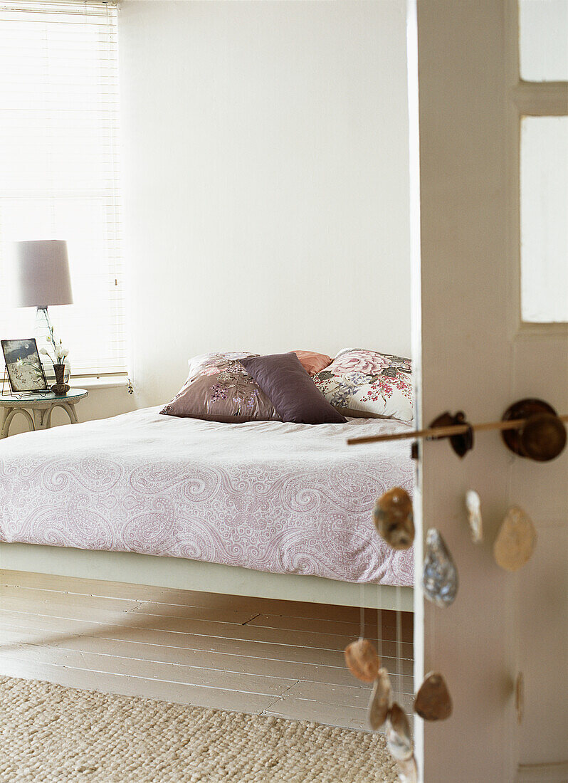 Neutrally decorated bedroom with paisley throw