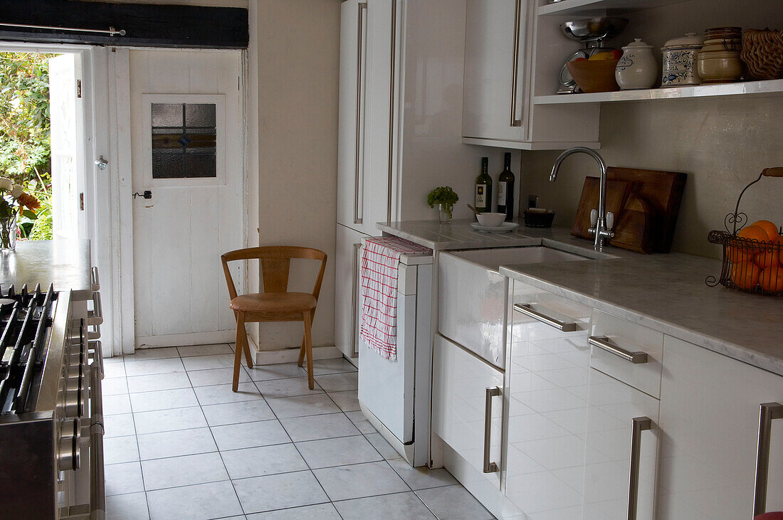 White Hastings kitchen with tiled floor and open back door