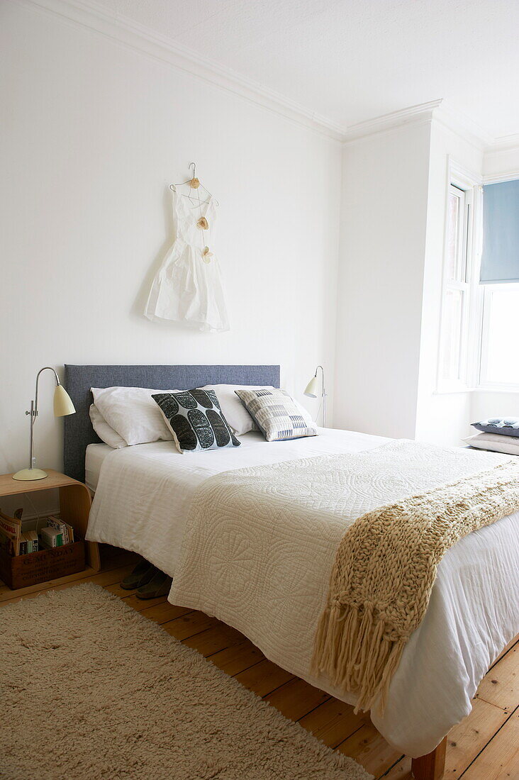 Dress hanging above bed in Broadstairs home, Kent, England, UK