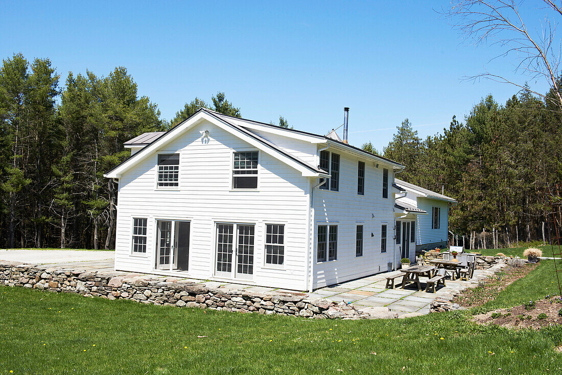 White detached exterior of Austerlitz home with terrace in Columbia County, New York, United States