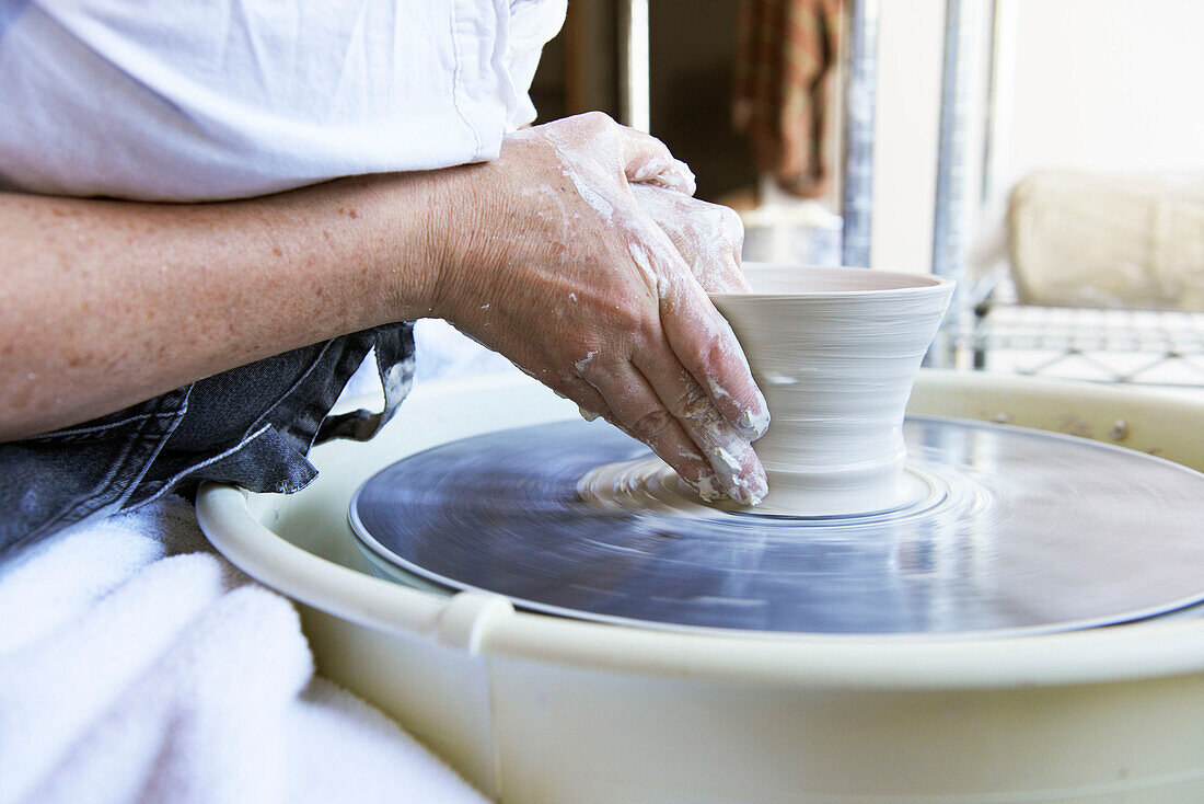 Woman shaping vase on potters wheel, Austerlitz, Columbia County, New York, United States