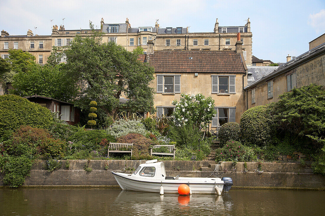 Moored motorboat in front of mansion