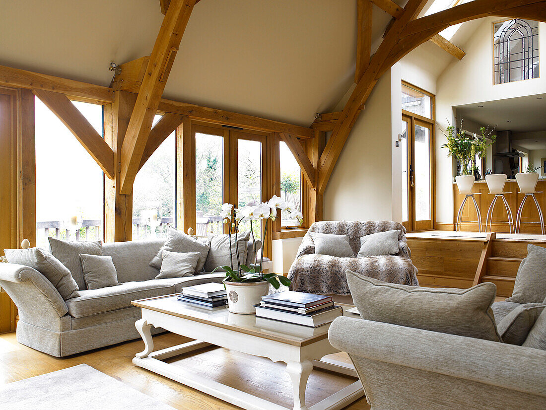 Orchid on coffee table in split-level open plan timber framed living room Somerset new build in rural England UK