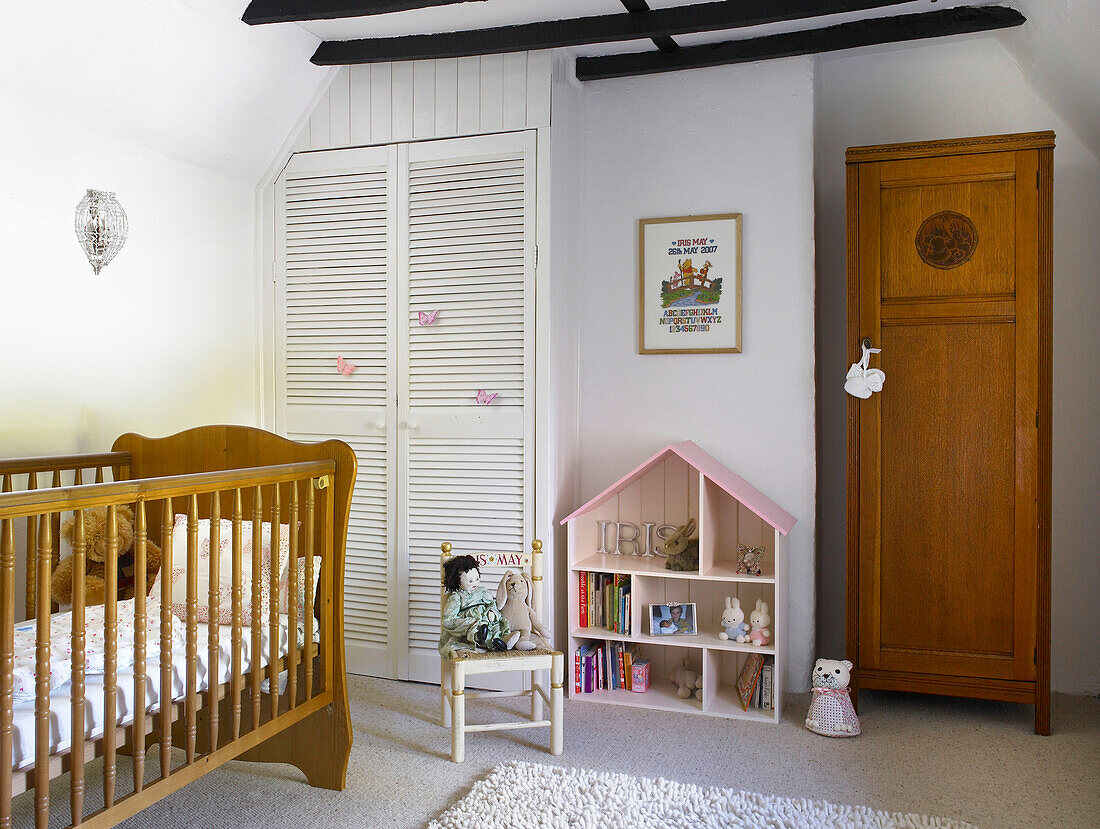 Dolls house shelving with wardrobe and crib in child's room of Buckinghamshire cottage England UK