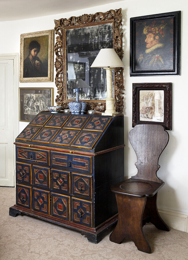 Antique writing bureau and wooden chair with artwork in Gloucestershire home, England, UK