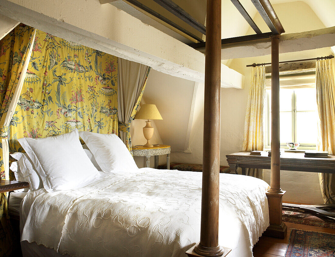 Four postered bed and ceiling beam in bedroom of Gloucestershire farmhouse, England, UK