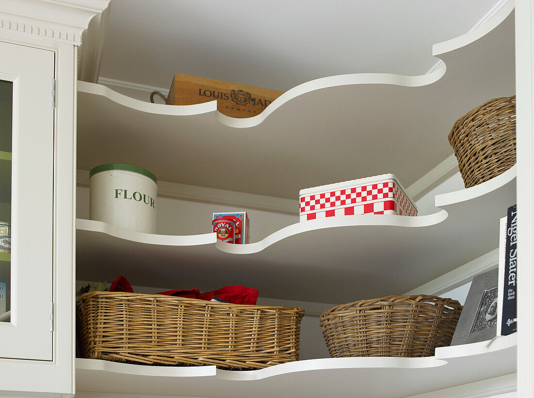 Baskets and storage containers on kitchen shelf in city of Bath home Somerset, England, UK