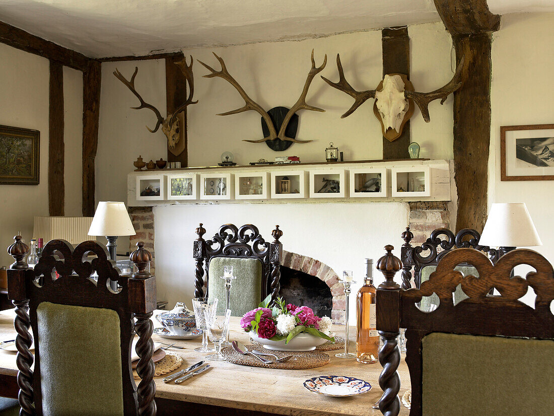 Wall mounted antlers in dining room of country house Suffolk, England, UK