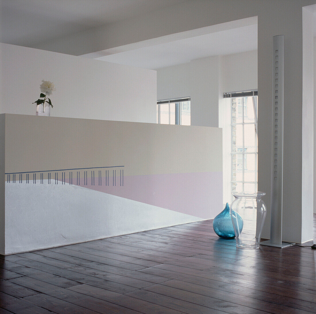 Contemporary empty loft space with partition walls floor boards and a painted wall mural