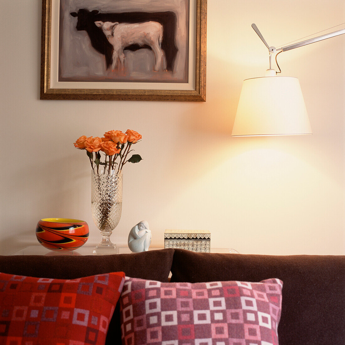 Sofa mit bunten Kissen und Sideboard mit Lampe in einem Wohnzimmer (Detailaufnahme)