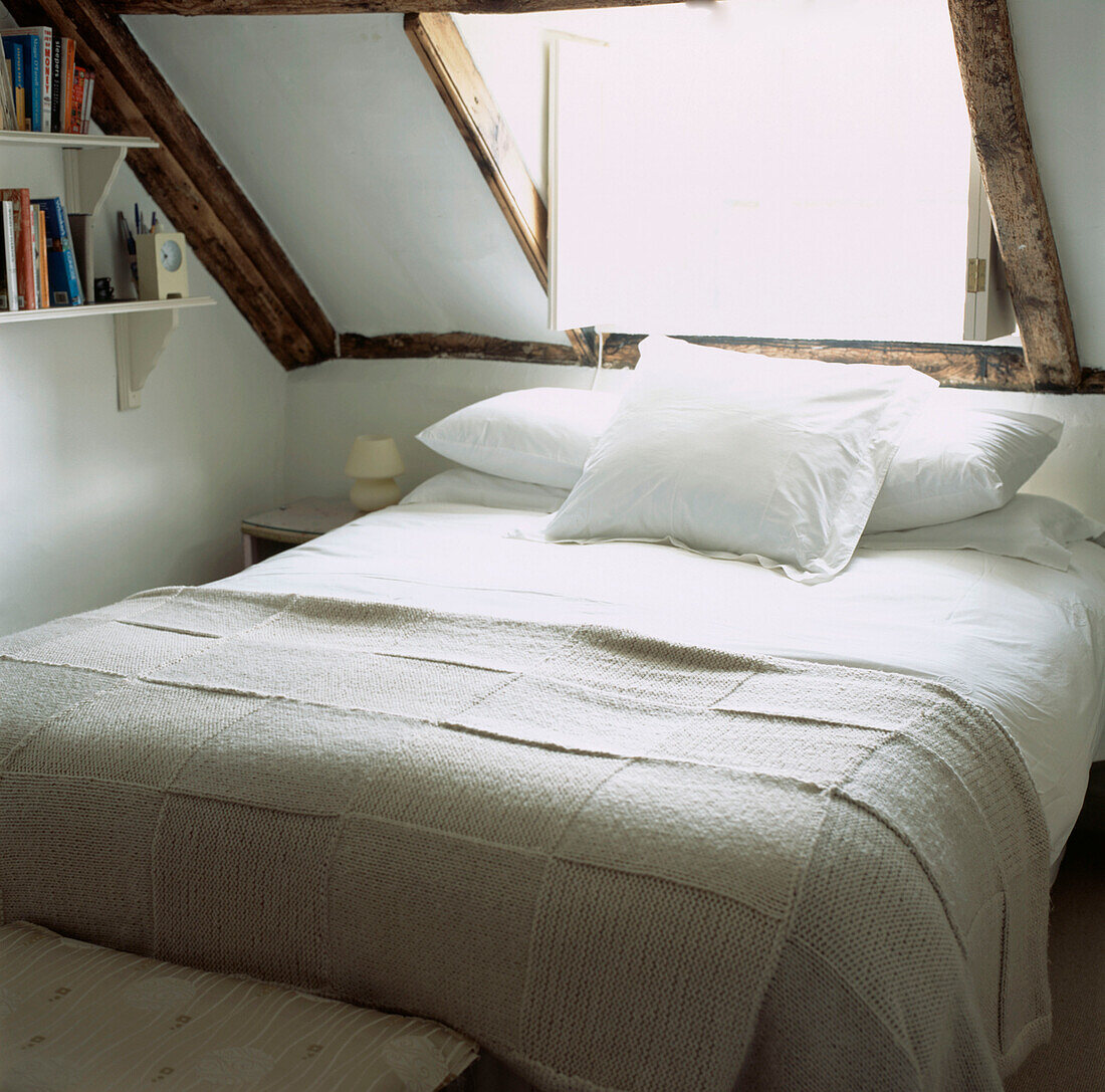 Small beamed attic bedroom with eaves and a double bed